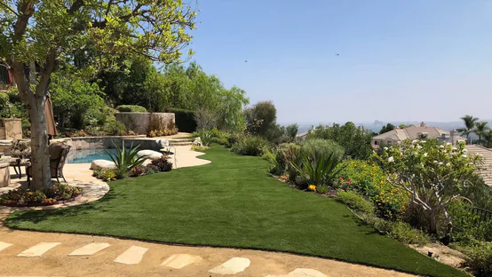 Lush artificial grass lawn installed across a hillside backyard